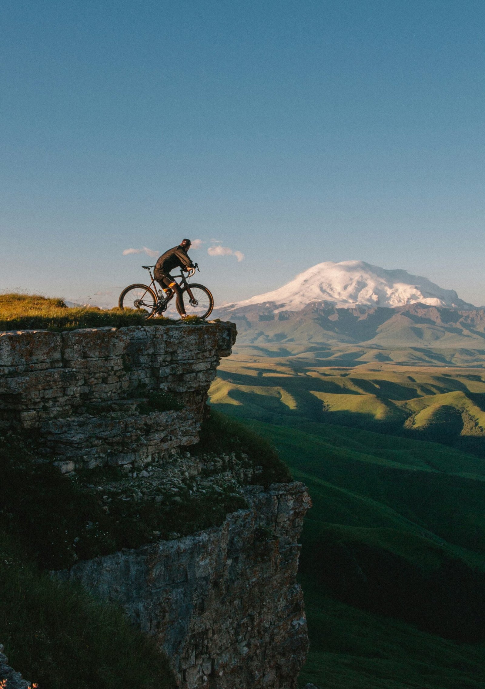 man riding bike on cliff at daytime